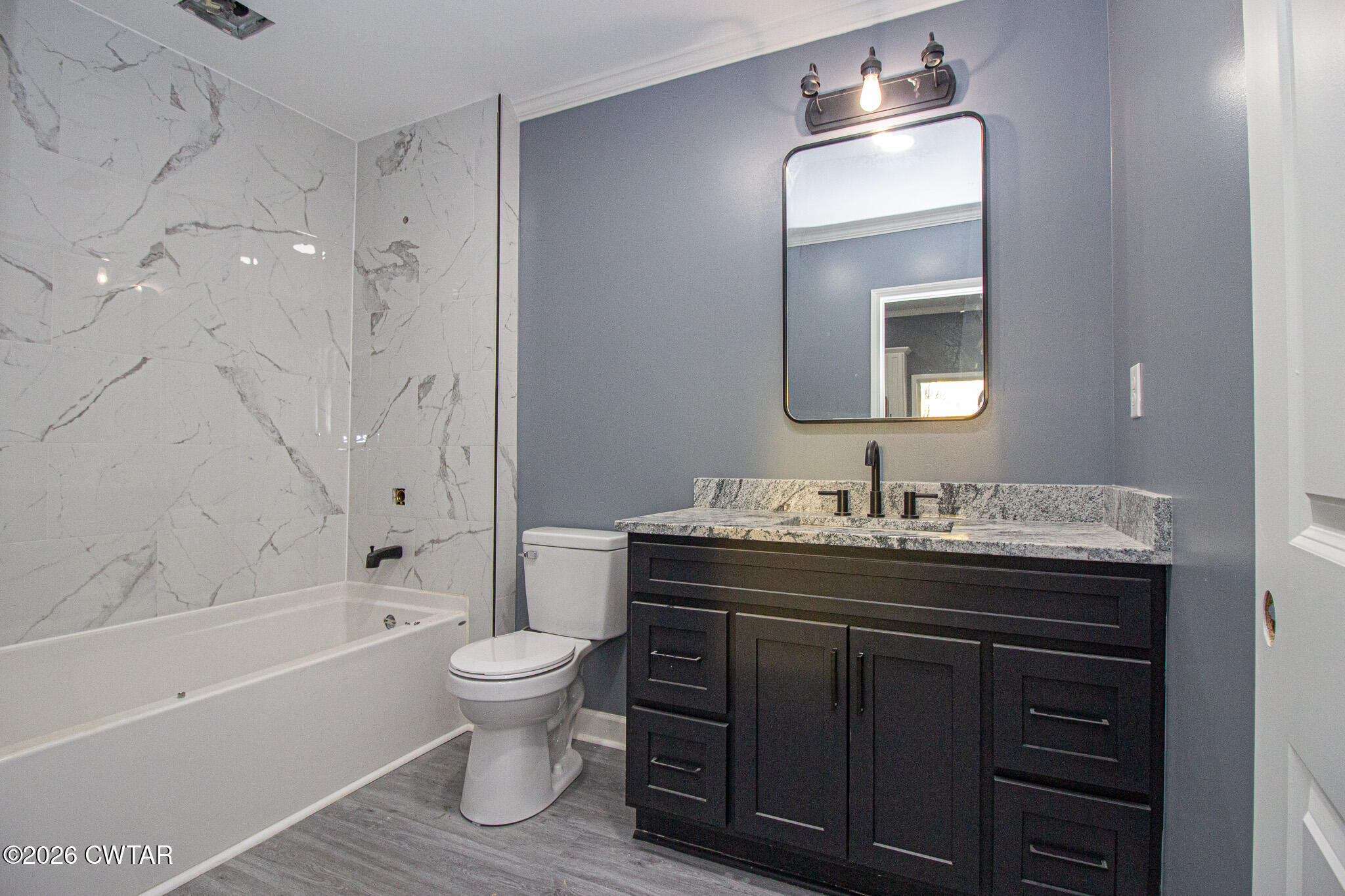 6523 Alamo Gadsden Road Gadsden, TN 38337 - Photo 12 of 25 a bathroom with a granite countertop sink toilet a large mirror a bathtub and shower