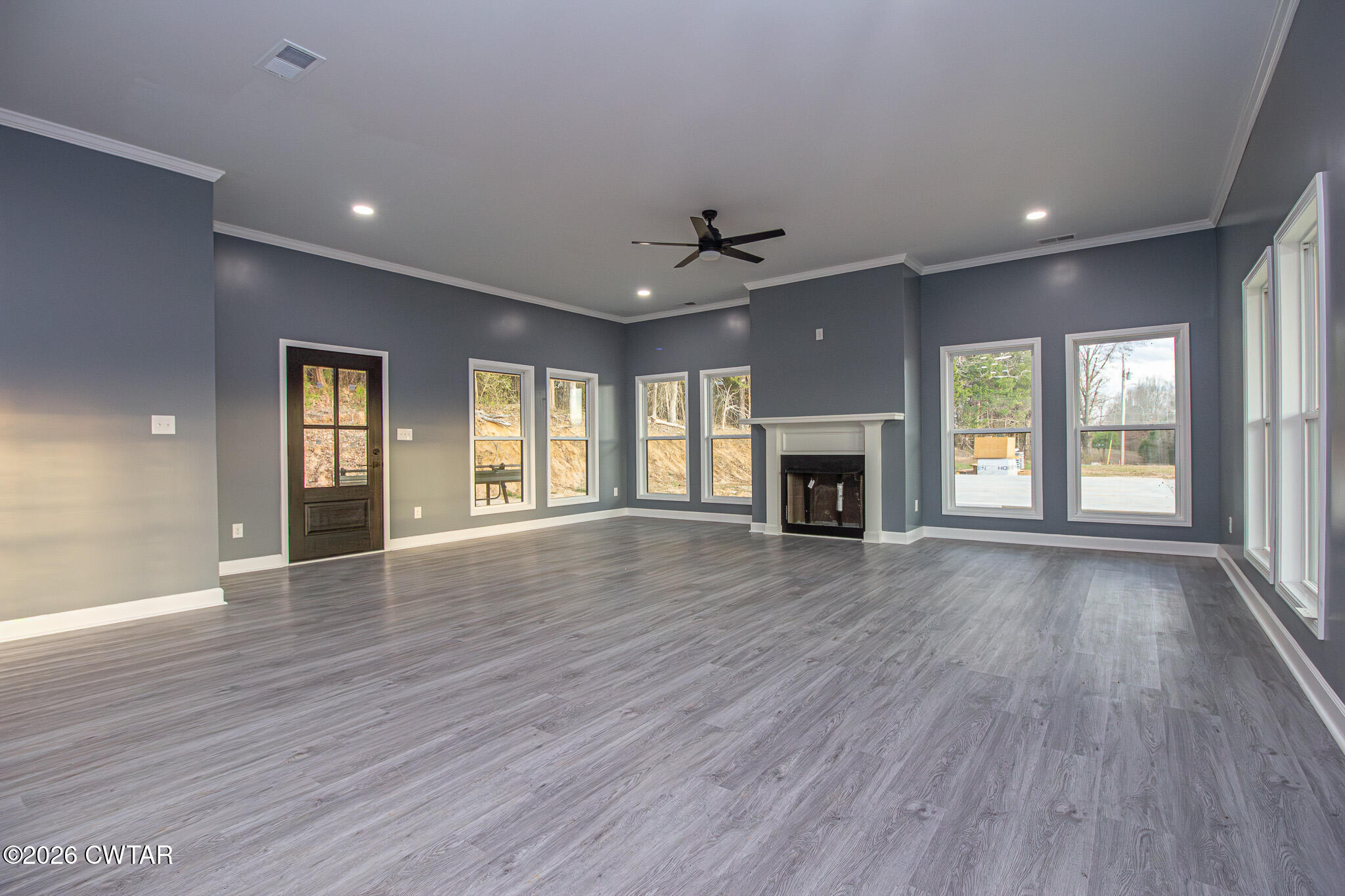 6523 Alamo Gadsden Road Gadsden, TN 38337 - Photo 5 of 25 an empty room with wooden floor fireplace and windows