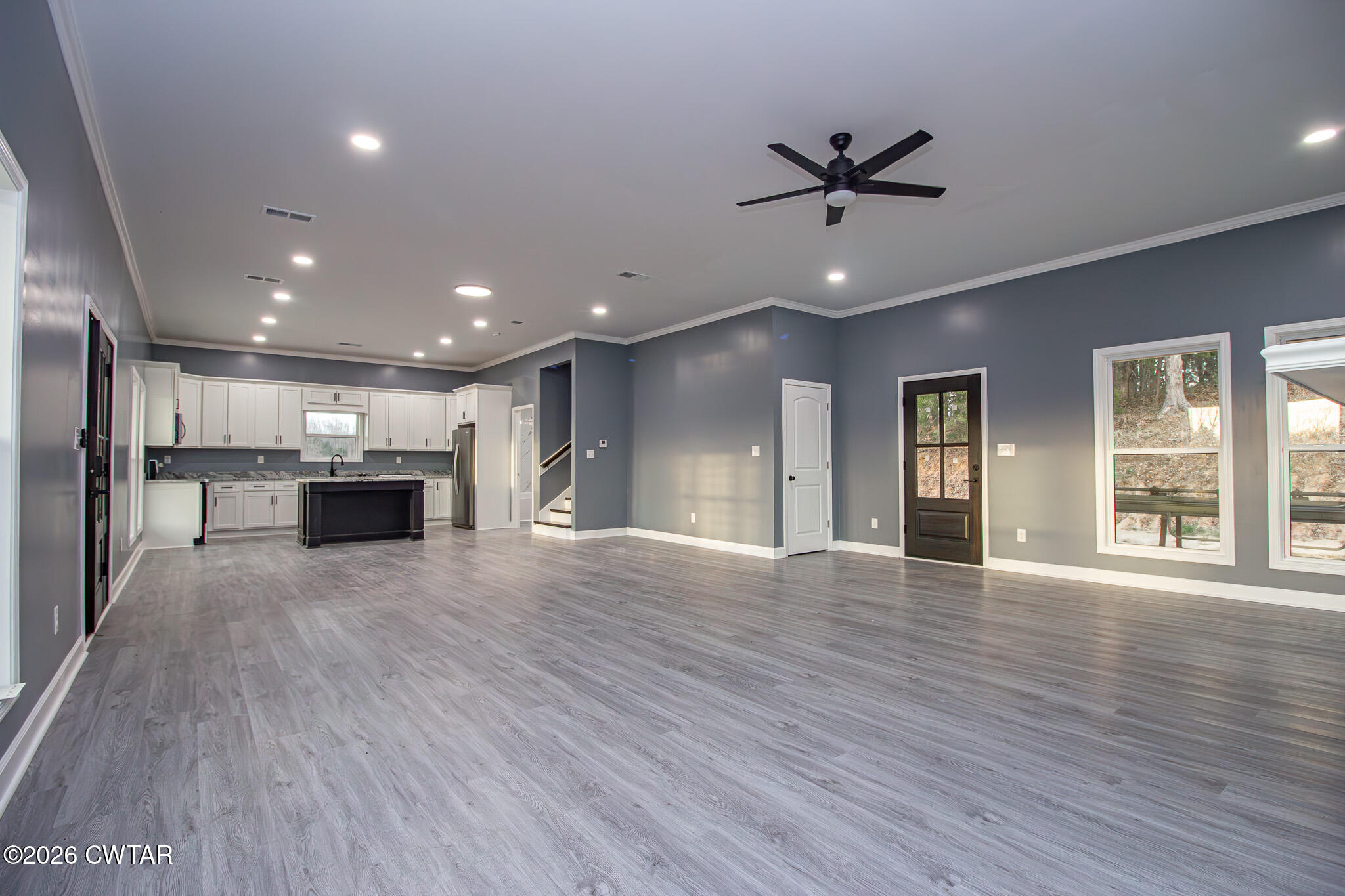 6523 Alamo Gadsden Road Gadsden, TN 38337 - Photo 6 of 25 a view of an empty room with wooden floor and a kitchen