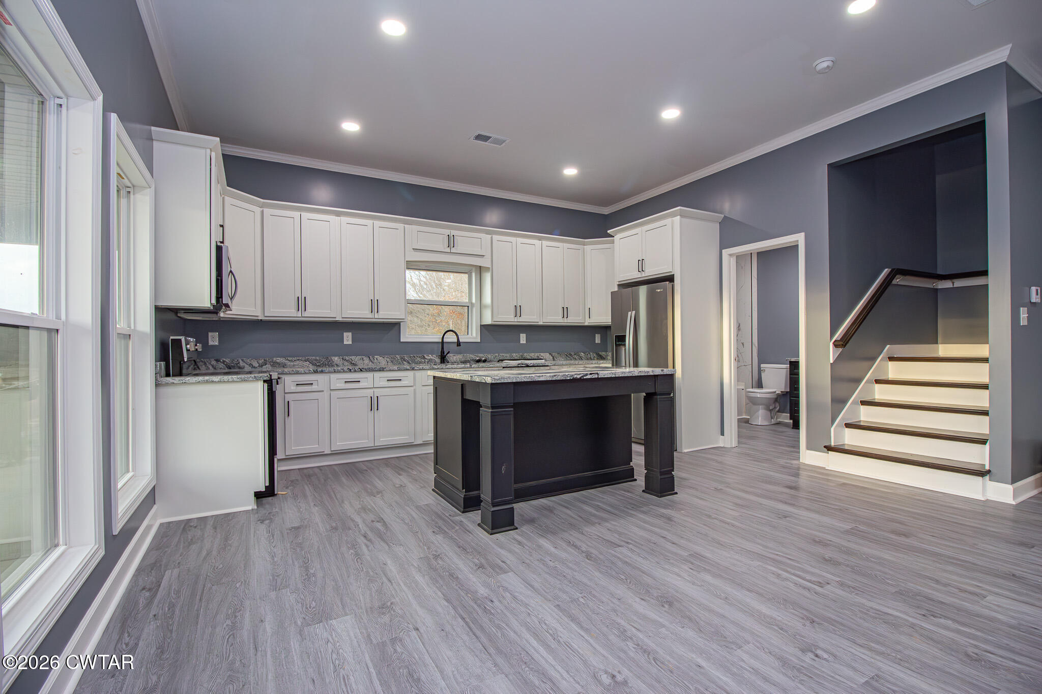 6523 Alamo Gadsden Road Gadsden, TN 38337 - Photo 7 of 25 a kitchen with kitchen island wooden floors appliances and white cabinets