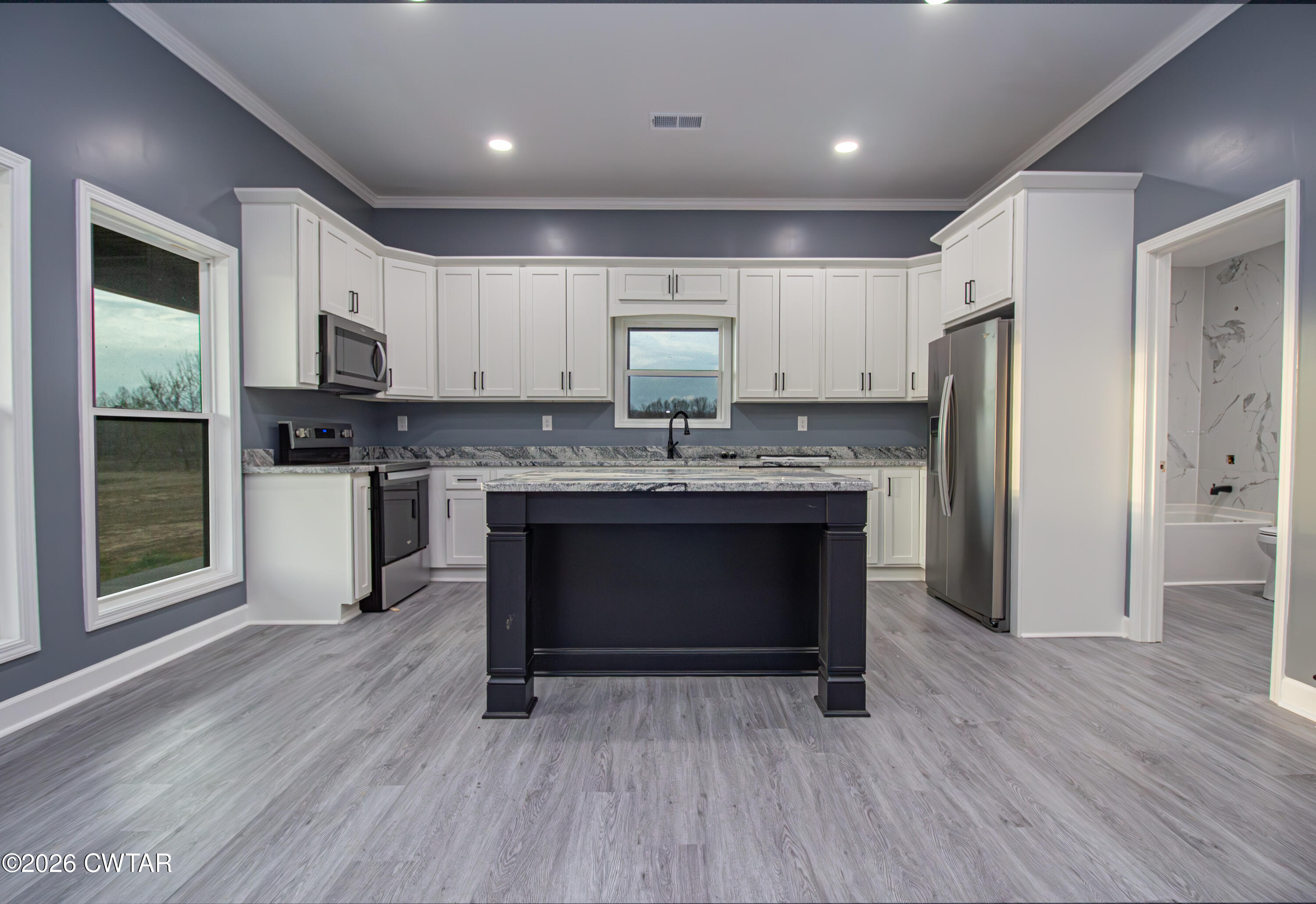 6523 Alamo Gadsden Road Gadsden, TN 38337 - Photo 8 of 25 a kitchen with stainless steel appliances granite countertop a stove a refrigerator and a microwave oven with wooden floor