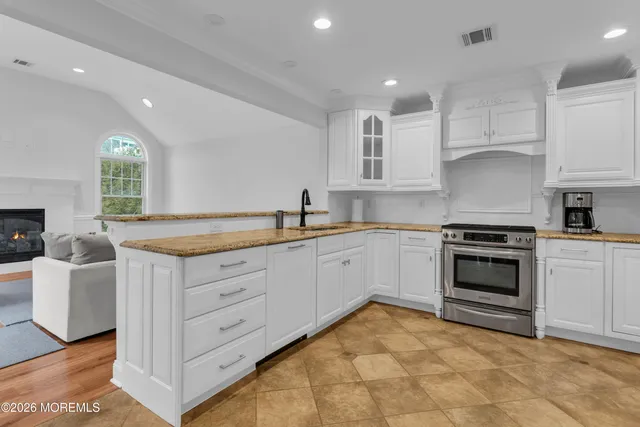 a kitchen with granite countertop a stove sink and cabinets