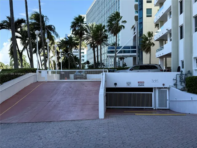 a view of a swimming pool with a yard and palm trees
