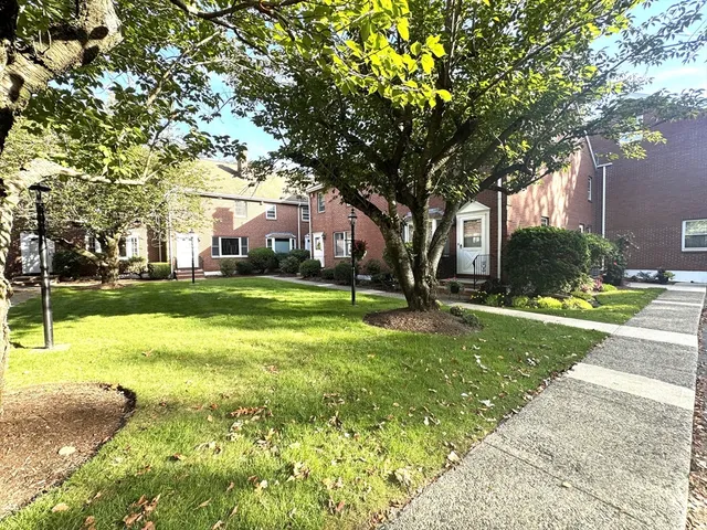 a view of a house with a big yard and large trees