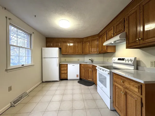 a kitchen with a cabinets a refrigerator and a sink