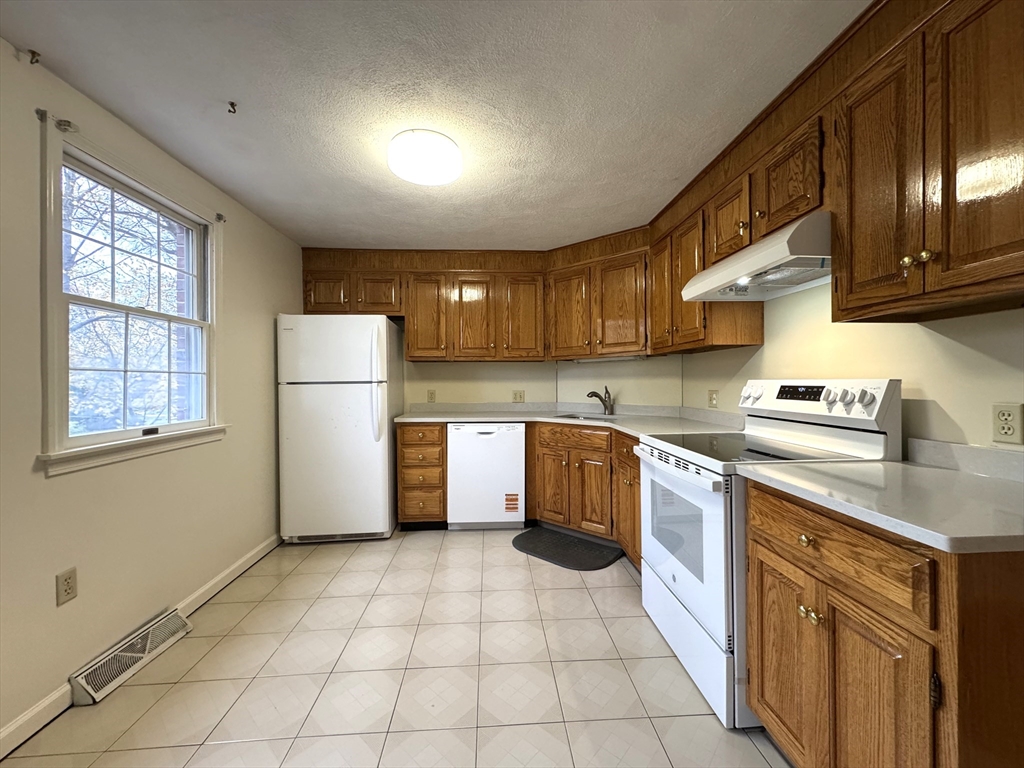 224 Park Street, Unit C8 Stoneham, MA 02180 - Photo 3 of 18 a kitchen with a cabinets a refrigerator and a sink