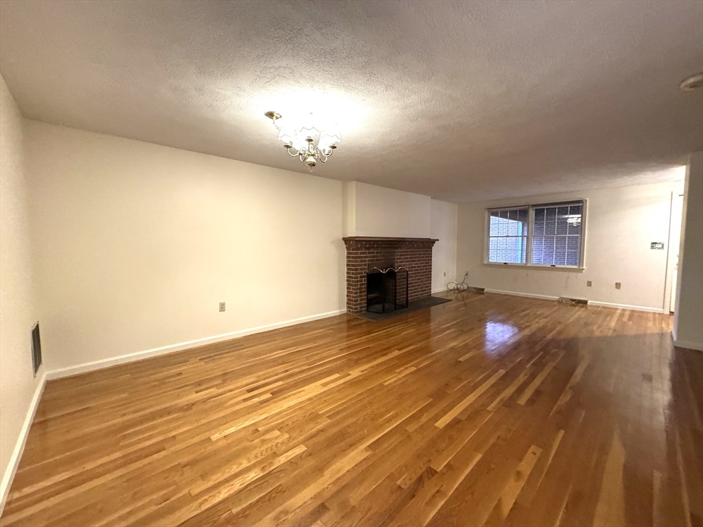 224 Park Street, Unit C8 Stoneham, MA 02180 - Photo 6 of 18 a view of empty room with wooden floor and fireplace