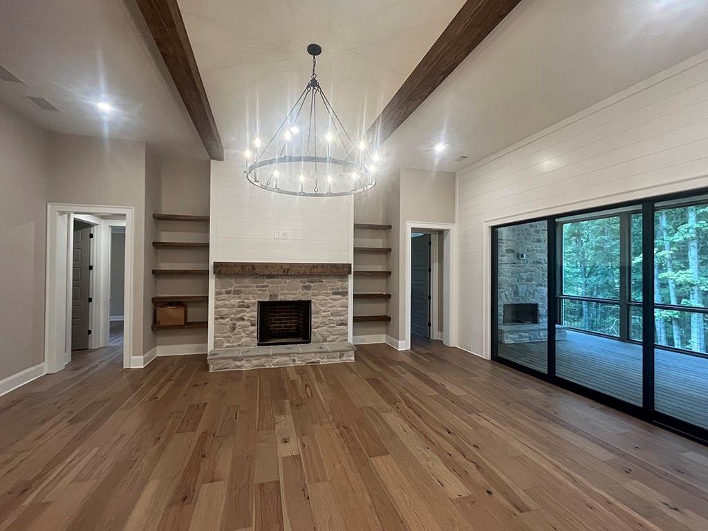 711 Hornage Road Ball Ground, GA 30107 - Photo 12 of 61 wooden floor in an empty room with a fireplace