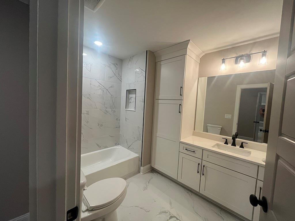 711 Hornage Road Ball Ground, GA 30107 - Photo 28 of 61 a bathroom with a bathtub shower sink vanity and toilet