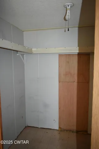 a view of a backyard with plants and large trees