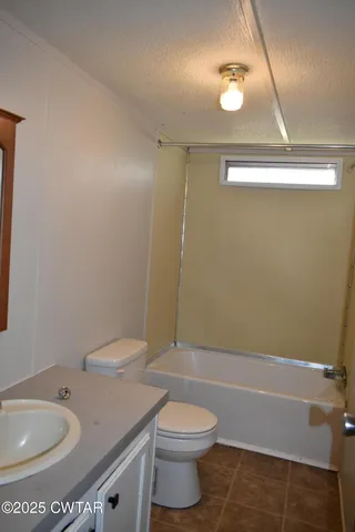 a bedroom with a bed next to a window and a lamp