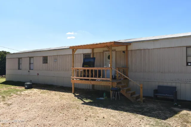 a backyard of a house with lots of green space and outdoor seating