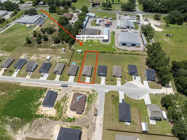 a aerial view of a residential apartment building with a yard and parking spaces