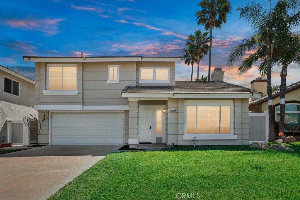 26658 Caravan Circle Corona, CA 92883 - Photo 2 of 50 a view of a white house with a large windows and a yard with palm trees