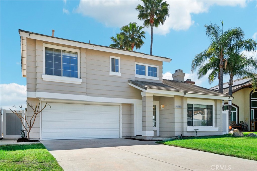 26658 Caravan Circle Corona, CA 92883 - Photo 3 of 50 a front view of a house with a garden and palm trees