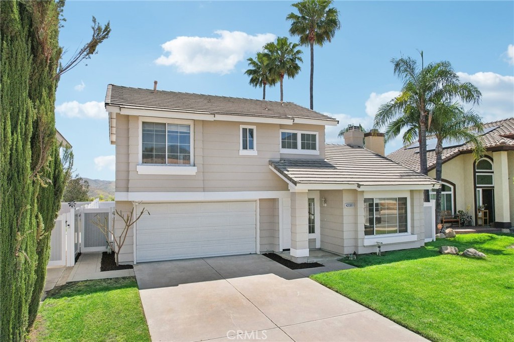 26658 Caravan Circle Corona, CA 92883 - Photo 6 of 50 a front view of a house with a garden and yard