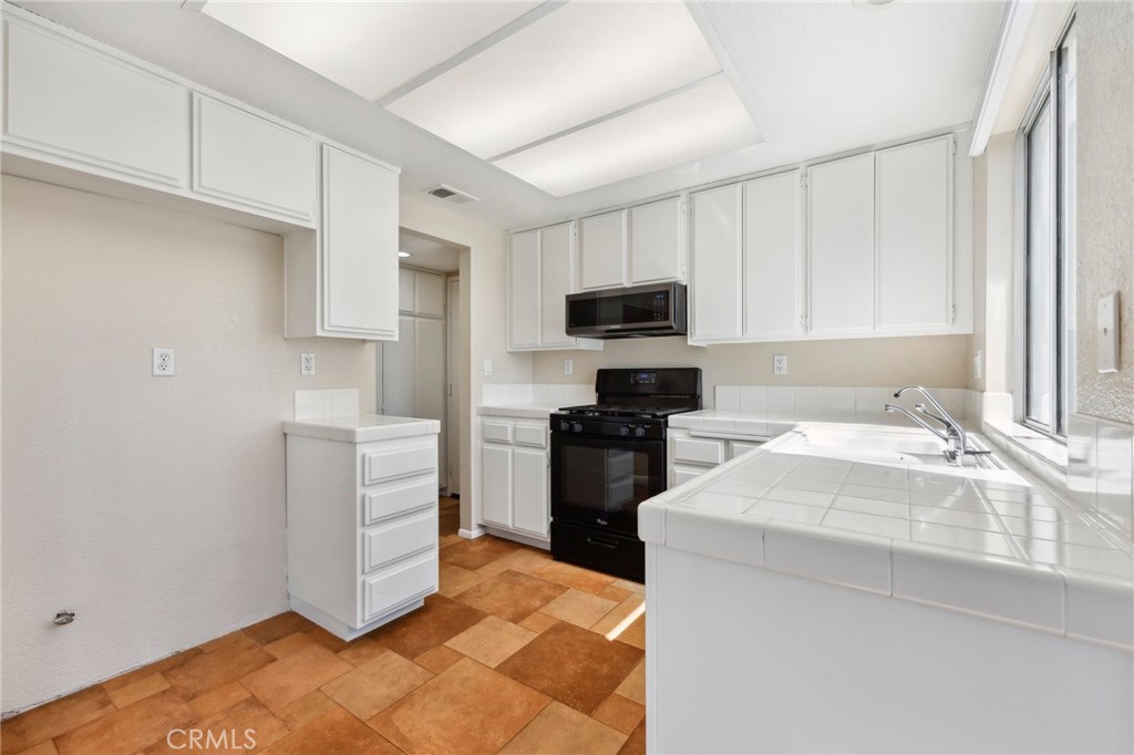 26658 Caravan Circle Corona, CA 92883 - Photo 9 of 50 a kitchen with a sink stove and refrigerator