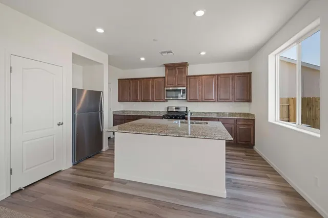 a kitchen with stainless steel appliances granite countertop a sink stove and refrigerator