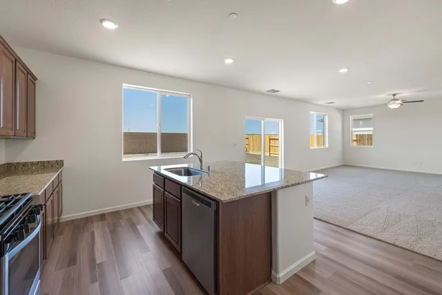 a kitchen with granite countertop a stove and a sink