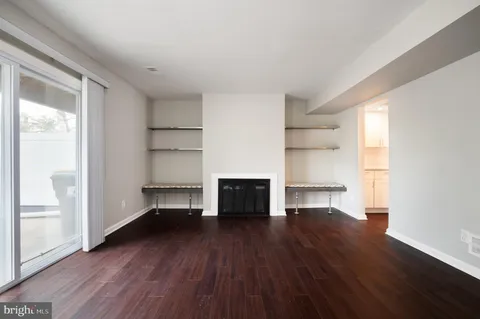 a view of empty room with a fireplace and wooden floor