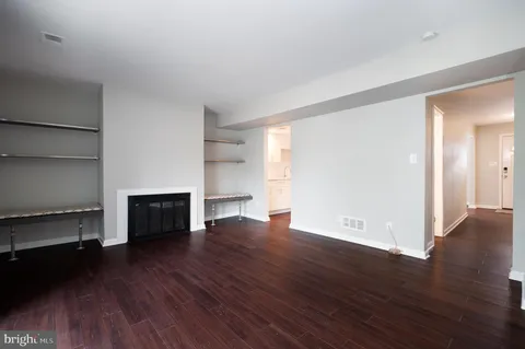 a view of empty room with wooden floor and fireplace