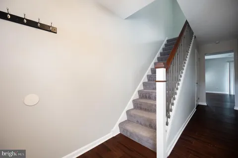 a view of staircase with wooden floor and white walls