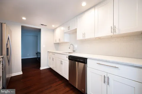 a kitchen with granite countertop white cabinets and white appliances