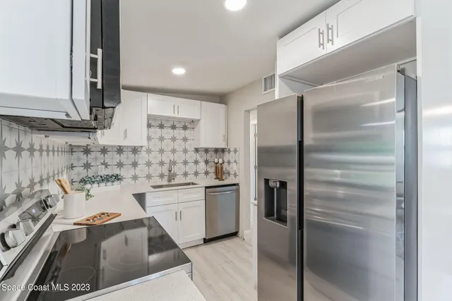a kitchen with a refrigerator sink and cabinets