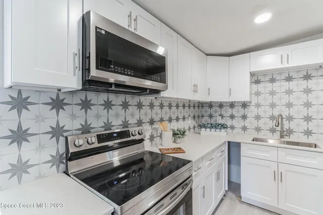 a kitchen with stainless steel appliances granite countertop a refrigerator and a wooden floor
