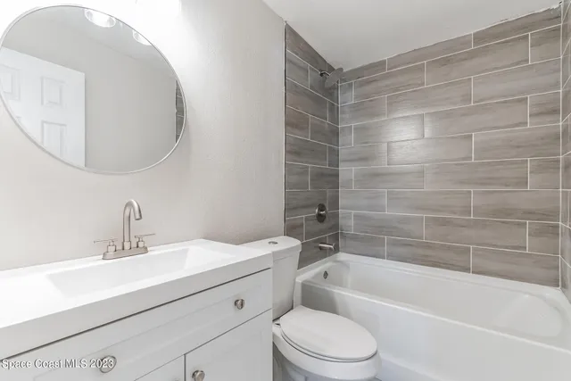 an empty room with wooden floor ceiling fan and window