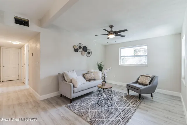a living room with furniture and a ceiling fan