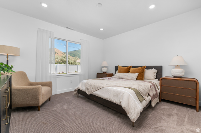 1352 West 2350 South, Unit 18 Perry, UT 84302 - Photo 11 of 26 Spacious bedroom featuring neutral carpeting, recessed lighting, and a large window with mountain scenery
