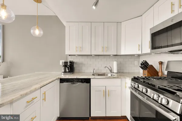 a kitchen with stainless steel appliances granite countertop a sink a stove and a microwave