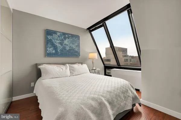 a large bed sitting in a bedroom next to a window
