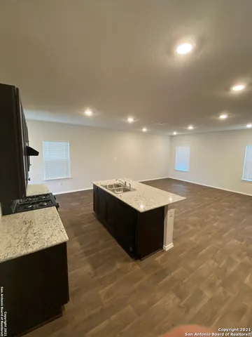 a large room with lot of kitchen sink granite counter tops and a view of living room