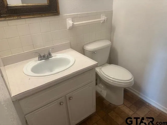 a bathroom with a sink a toilet and a mirror