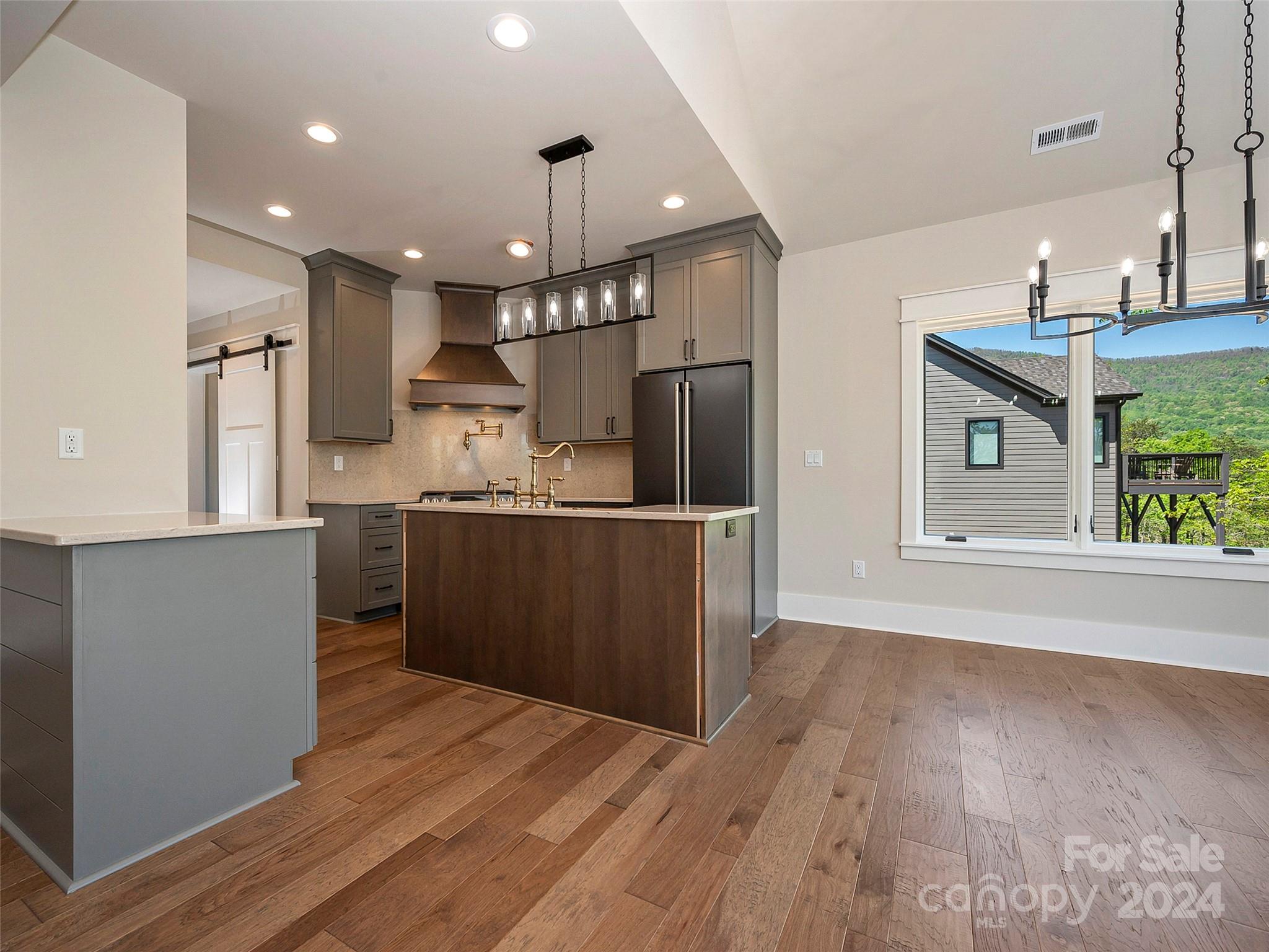 87 Jackson Ridge Ln Mill Spring, Unit 4 Mill Spring, NC 28756 - Photo 20 of 48 a kitchen with stainless steel appliances granite countertop a refrigerator a sink dishwasher a stove and a wooden floors