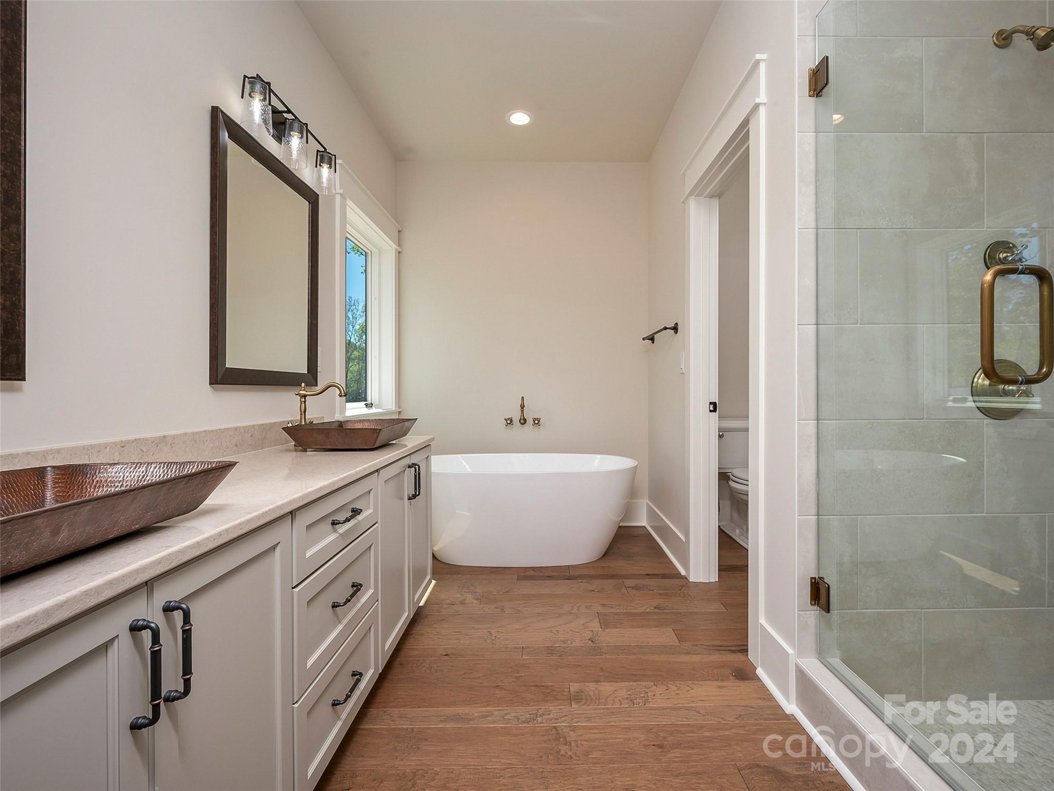 87 Jackson Ridge Ln Mill Spring, Unit 4 Mill Spring, NC 28756 - Photo 31 of 48 a spacious bathroom with a double vanity sink a mirror and a bathtub