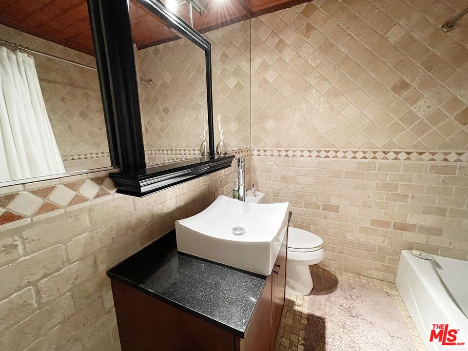 6464 Newcastle Avenue Reseda, CA 91335 - Photo 15 of 17 a bathroom with a sink a toilet and mirror