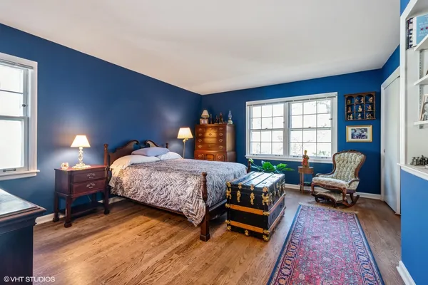 a bedroom with a bed wooden floor and window