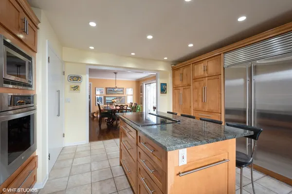 a kitchen with stainless steel appliances granite countertop a sink and a refrigerator