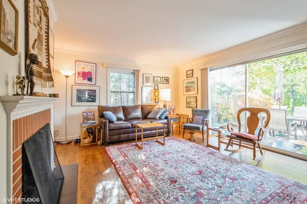 a living room with furniture a fireplace and a floor to ceiling window