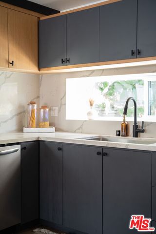 a kitchen with a sink a refrigerator and cabinets