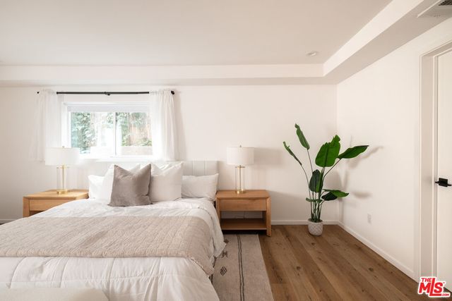 a bedroom with a bed and a potted plant