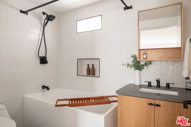 a bathroom with a sink a mirror and a shower