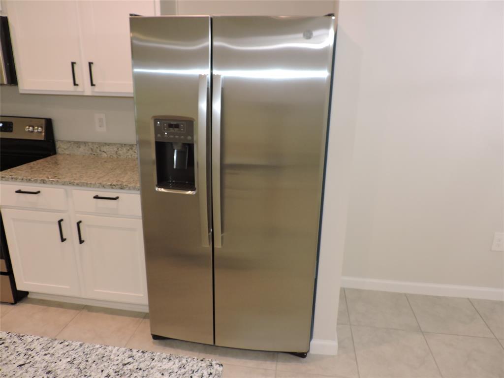 836 Persimmon Place Fort Pierce, FL 34981 - Photo 13 of 78 a view of a refrigerator in kitchen and white cabinets