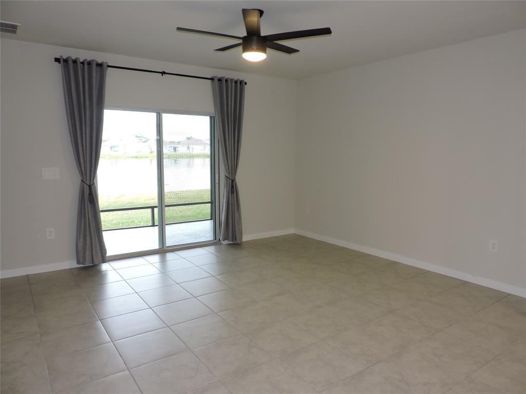 836 Persimmon Place Fort Pierce, FL 34981 - Photo 22 of 78 an empty room with chandelier fan and windows