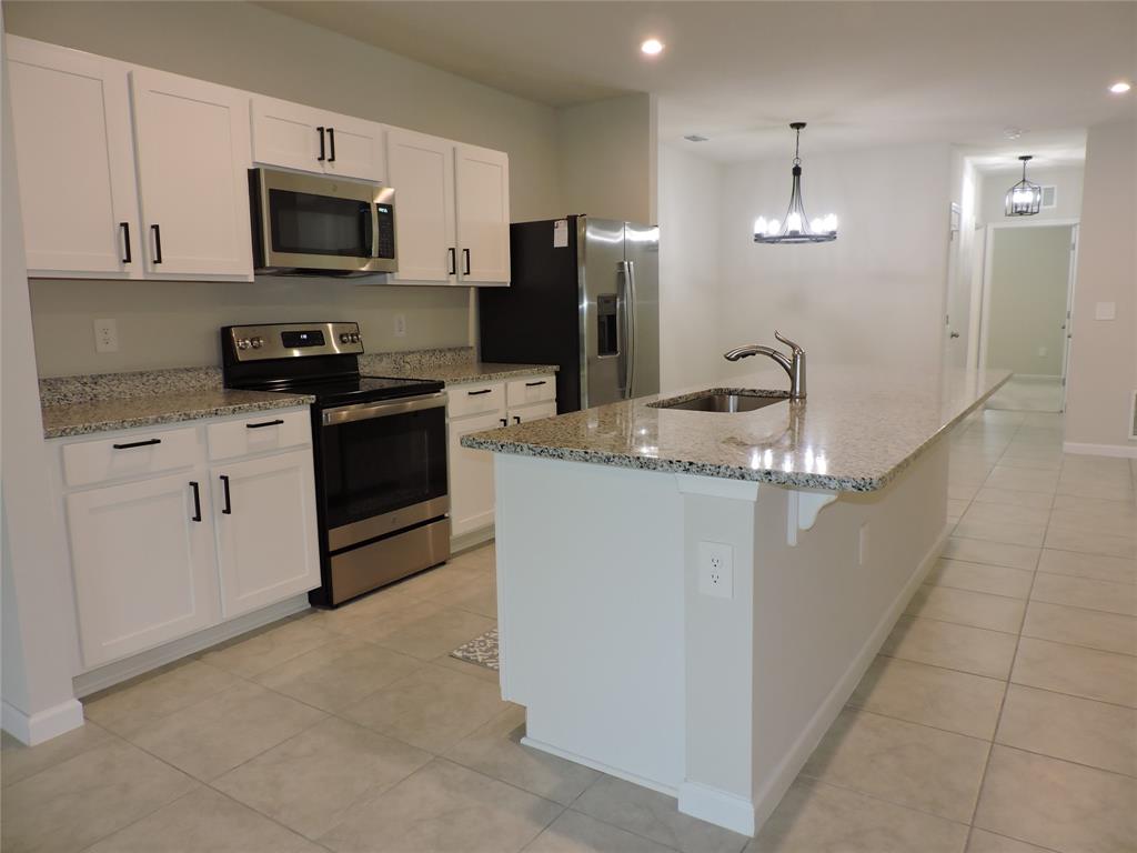 836 Persimmon Place Fort Pierce, FL 34981 - Photo 10 of 78 a kitchen with stainless steel appliances granite countertop a refrigerator a stove a sink a microwave and a refrigerator