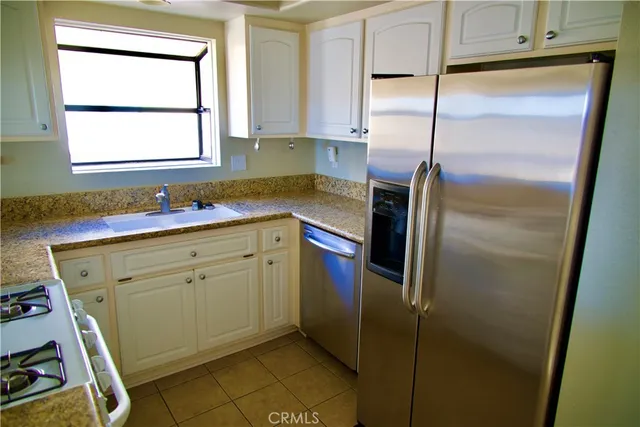 a kitchen with a refrigerator sink and cabinets