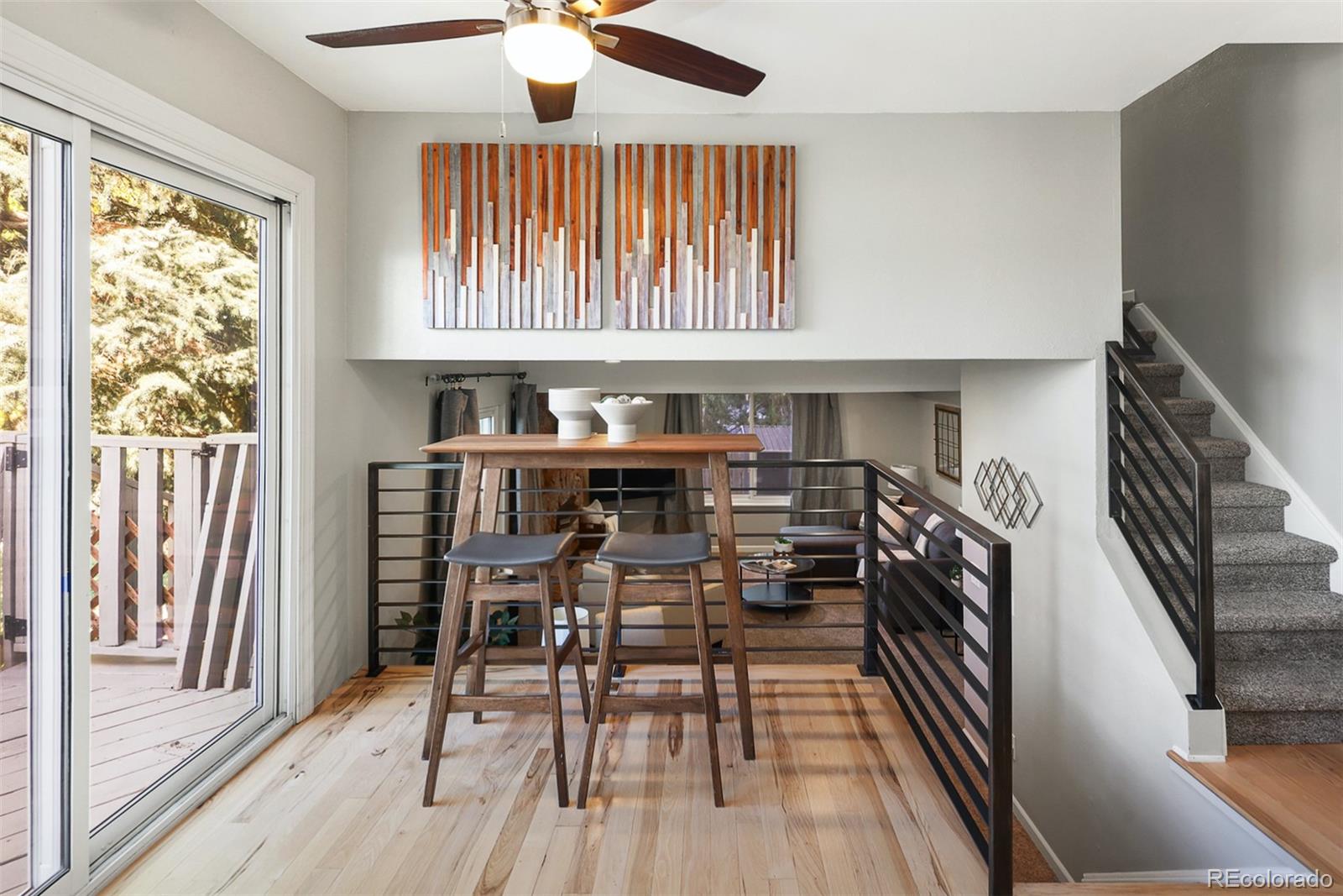 10499 Newcombe Street Westminster, CO 80021 - Photo 12 of 33 a dining room with wooden floor a chandelier a wooden table and chairs